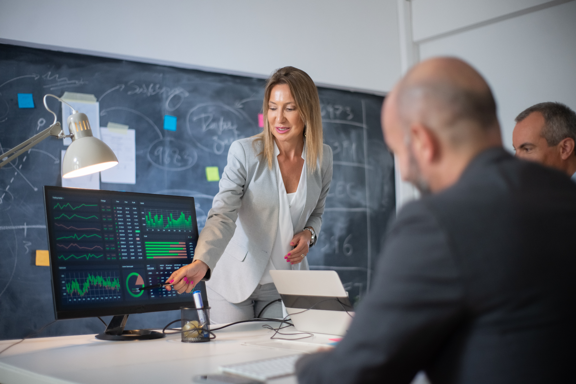 Female business leader presenting revenue cycle analytics and profit growth charts to colleagues